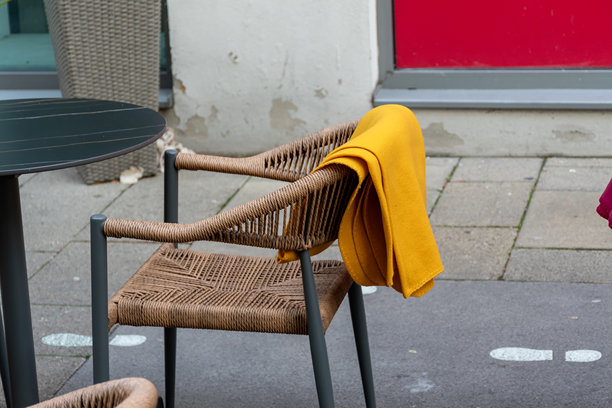 城市空间里夏日咖啡馆的柳条椅，配有鲜黄色的毯子图片下载