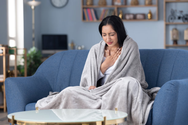 患有流鼻涕的年轻女子在家中沙发上休息的居家照片图片下载