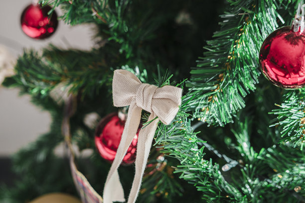 装饰有红色饰球、圣诞浆果、kokina（一种植物）、丝带和云舞者（一种颜色）蝴蝶结的人工新年或圣诞树图片下载