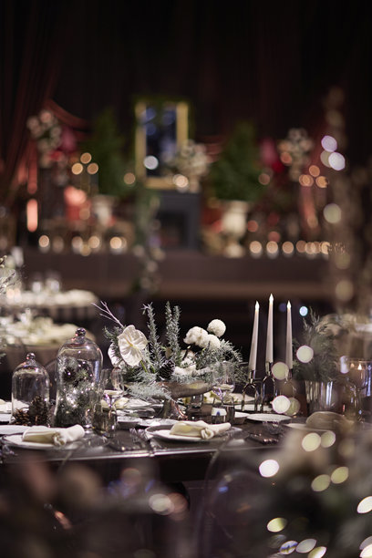 优雅的冬季主题餐桌布置，配有蜡烛和花卉装饰。素材图片图片下载