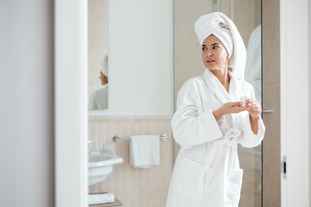 女子在浴室涂抹面霜的素材照片图片下载