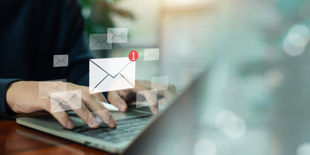 商务人士在笔记本电脑上打字，旁边有多个电子邮件图标和新消息通知，象征邮件沟通、收件箱管理、数字化工作流程、在线业务和客户支持。图片下载