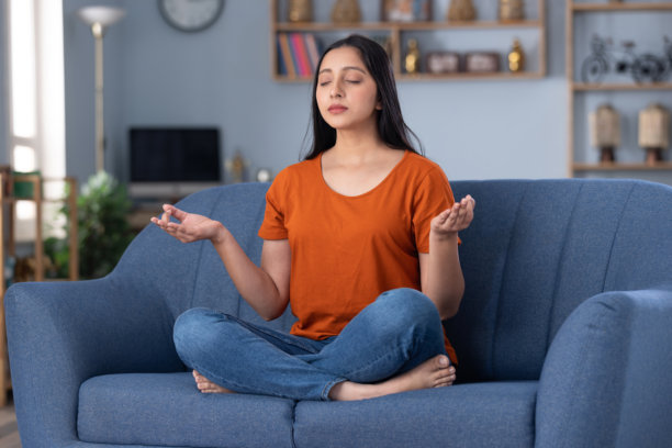 穿着休闲服饰的美丽年轻女孩在家中沙发上坐着的照片图片下载