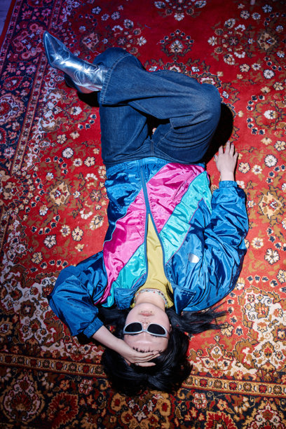 年轻亚裔女性穿着二手衣，在复古地毯上放松图片下载