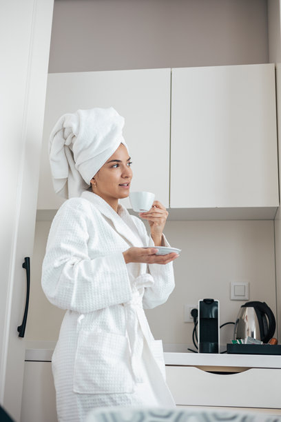 酒店房间内厨房里放松喝茶的女人素材图片图片下载