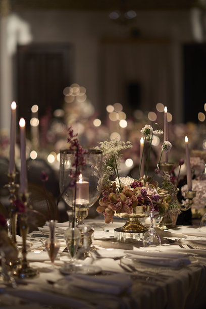 优雅的烛光婚礼餐桌布置，配有鲜花中心装饰品。素材图片图片下载