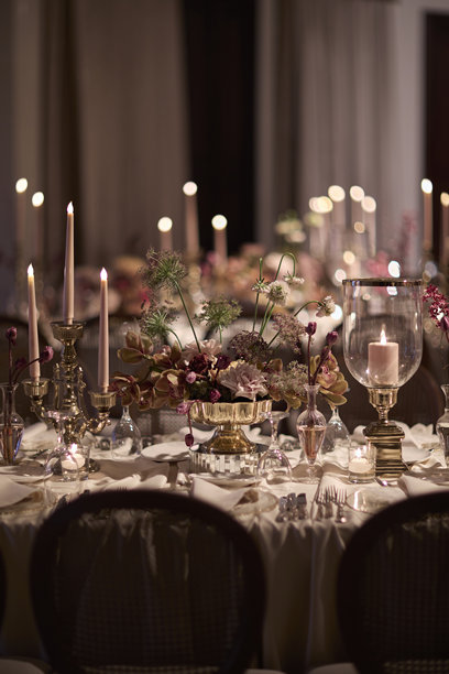 优雅烛光婚礼餐桌布置，配有鲜花中心装饰品。素材图片图片下载