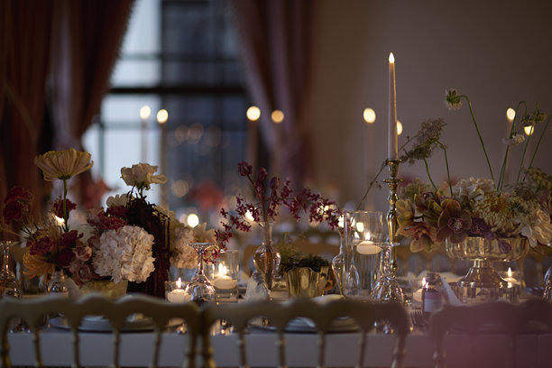 优雅的烛光婚礼餐桌布置，配有鲜花中心装饰品。素材图片图片下载