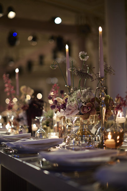 优雅的烛光婚礼餐桌布置，配有鲜花中心装饰品。素材图片图片下载