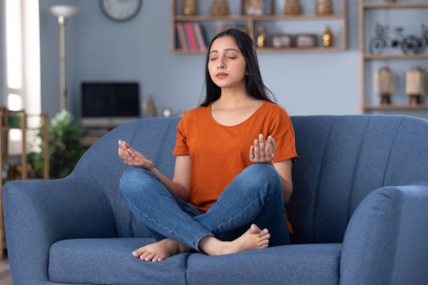 穿着休闲服装的美丽年轻女孩在家中沙发上坐着的照片图片下载