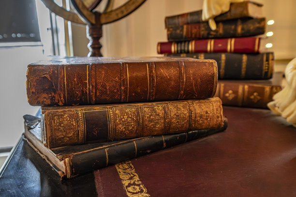 复古皮面书堆放在古董木桌上图片下载