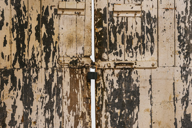 老旧木门。老旧木门纹理，有脱落的漆面、开裂的木板、金属锁扣，质感粗犷。自然复古，纹理可用作背景、衬托、样机、复古设计图片下载
