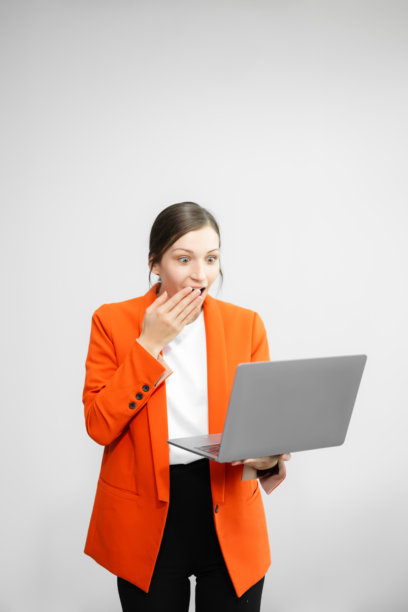 年轻美丽的女子肖像照，她感到开心，手持带有黑色空白屏幕的智能手机、平板电脑和笔记本电脑，背景为白色，可用作广告或产品展示概念。图片下载