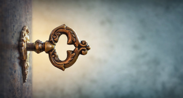 一张古老手稿背景下的锁孔中的旧钥匙，宏观摄影。复古风格。知识之钥。历史、教育、商业、安全、秘密背景的概念与想法。图片下载