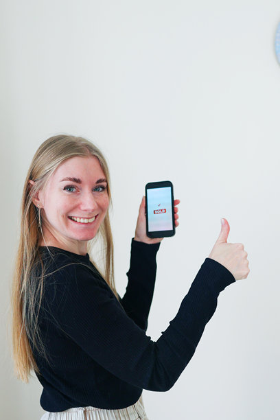 一位快乐的女性展示着手机屏幕上的“已售”状态。展示了移动商务、二手交易应用和现代数字生活方式，并留有复制空间。图片下载