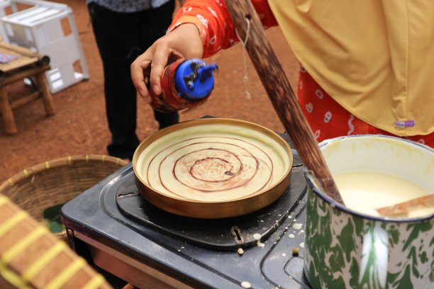 将巧克力混合物倒入模具中的蛋糕，呈热烤盘状图片下载