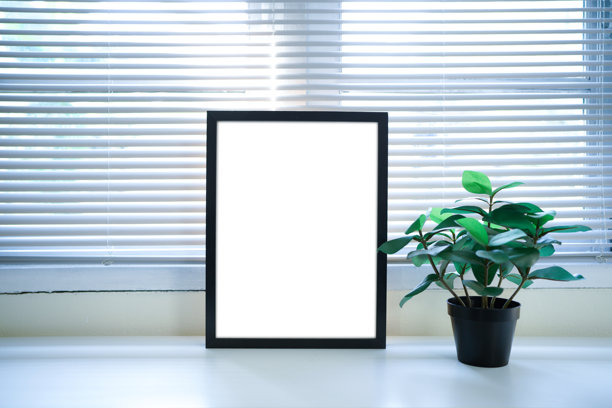 室内桌子上放着一个黑色画框，里面有植物，空白画布模板用于室内设计的样机、照片、图像、艺术品展示。乡村设计风格。图片下载