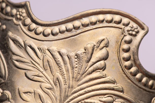 俄式复古金属茶杯架，表面有雕刻元素和图案，微距拍摄图片下载