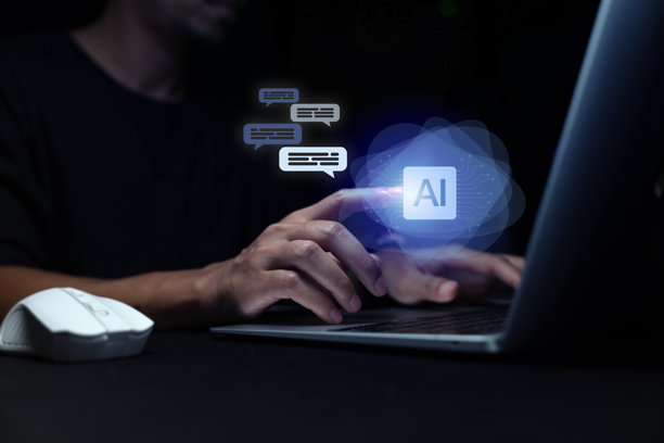 一名男子正在使用笔记本电脑或智能手机与人工智能（AI）互动、交谈，他正在使用AI助手、聊天机器人、ChatGPT等人工智能技术。图片下载