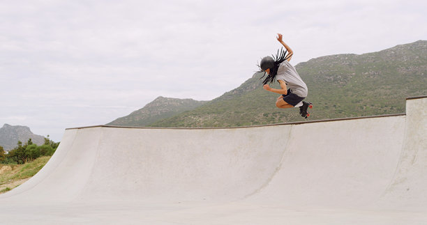 男子在公园的坡道上玩轮滑，做出跳跃动作，天空与空间展现速度、技巧或特技，发生在夏天。一位Z世代滑板爱好者在城市中进行户外运动训练，展现活力与技能。图片下载