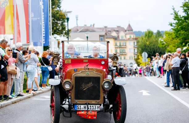 复古汽车游行，经典车爱好者们在一场热闹的街头节日中驾驶着历史悠久的车辆，观众们正在享受这一盛会。图片下载