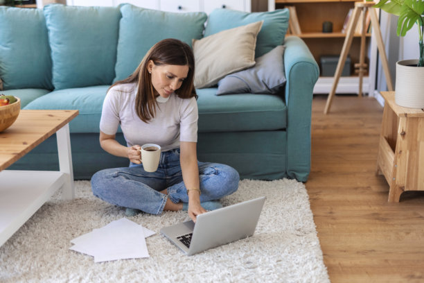 年轻女子在地板上使用笔记本电脑进行计划、创意构思、策略制定或网站审查的样机或肖像。一位充满活力、快乐的初创公司女员工正在使用科技进行网络社交或撰写博客。图片下载