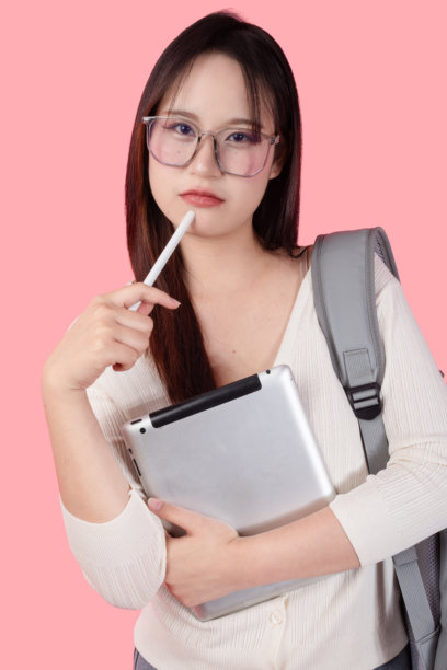 照片：一位快乐微笑的亚洲大学生少女，在工作室拍摄，背景为纯色，学习中的人们图片下载