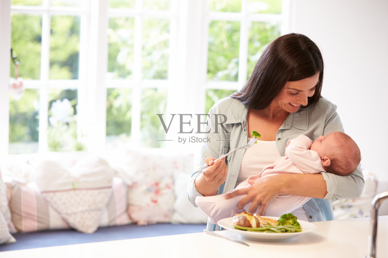 母亲和婴儿在厨房吃健康的食物正版图片素材