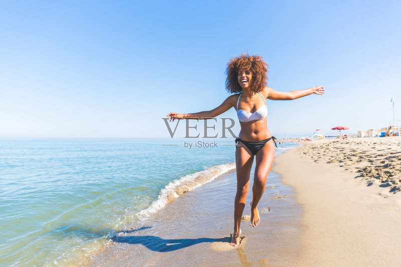 年轻的黑人妇女在海边玩正版图片素材