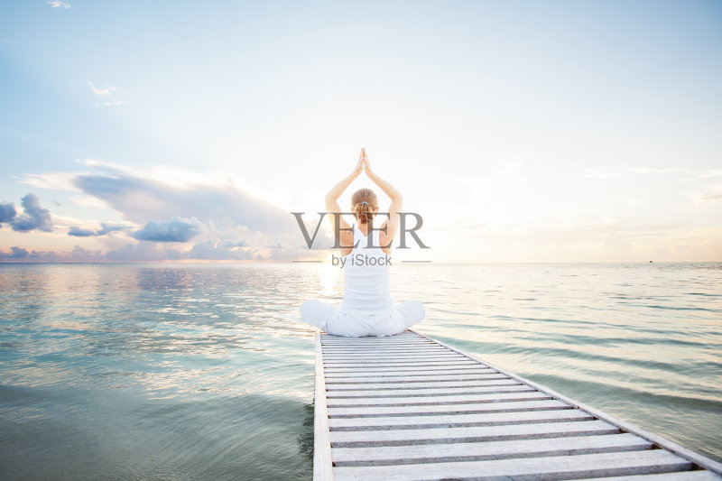 一个在海边练习瑜伽的白人女人正版图片素材