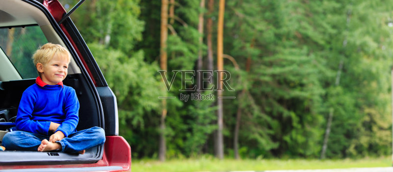 快乐的小男孩在夏天的自然中开车旅行正版图片素材