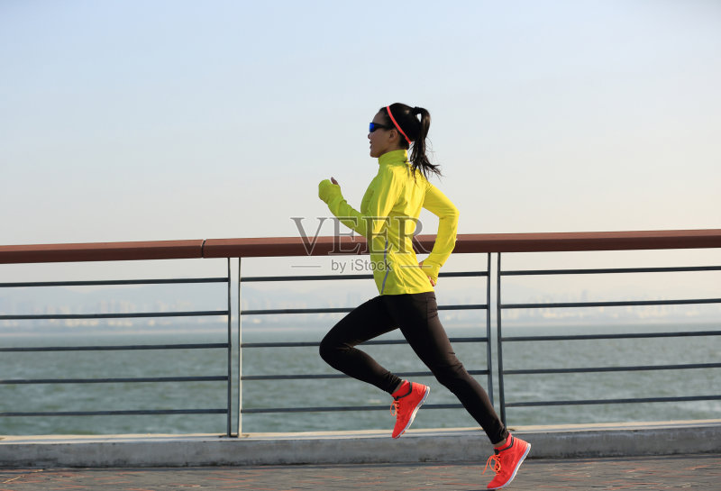 年轻的健身女运动员在海边跑步正版图片素材