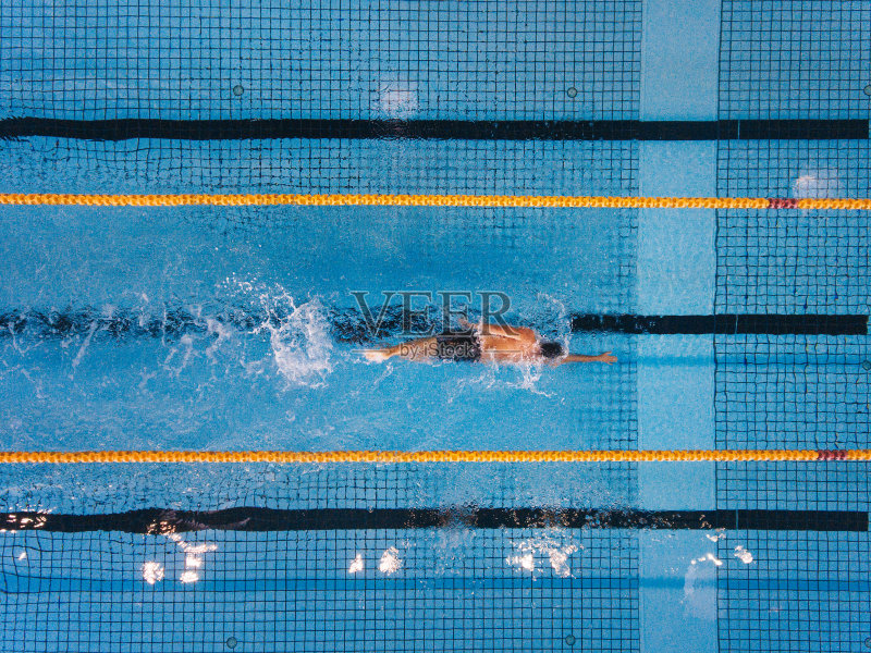 一个年轻人在游泳池里游来游去正版图片素材
