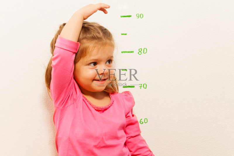 由小女孩在墙边测量身高正版图片素材