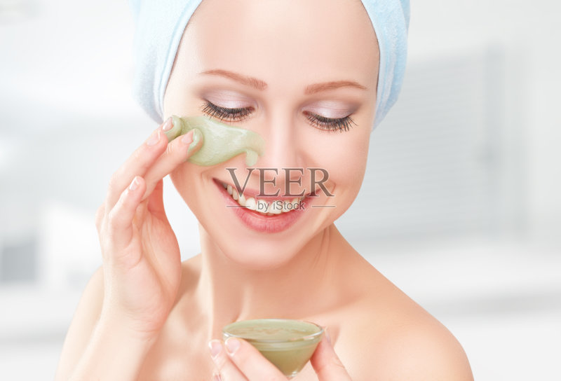 美丽的女孩在浴室和面膜面部皮肤护理正版图片素材