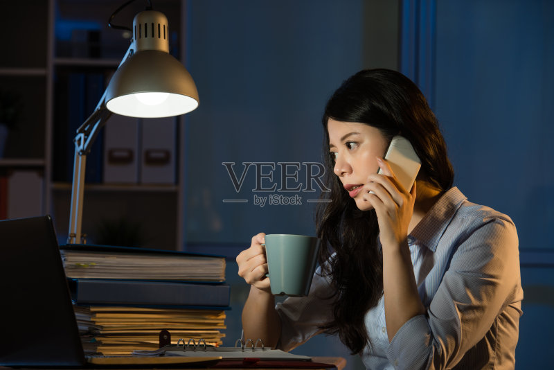 亚洲商业女性谈论智能手机加班正版图片素材