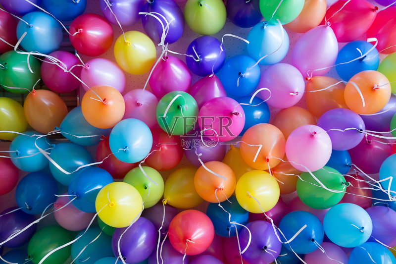 节日里，五颜六色的气球用氦气绑在白色的丝带上正版图片素材