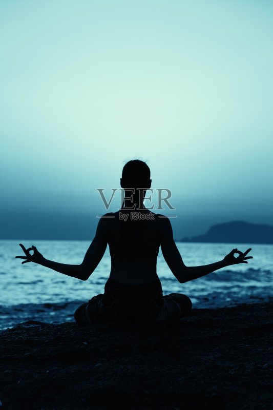 年轻健康的女人在海滩上练习瑜伽健身运动正版图片素材