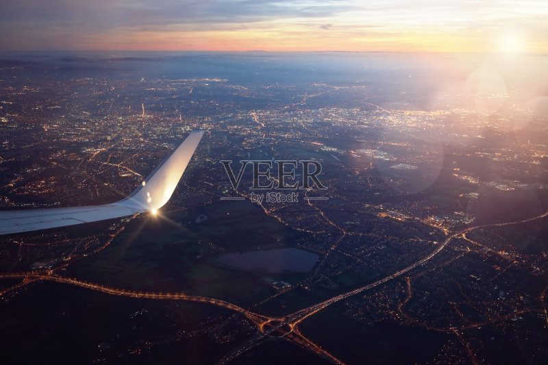 日落时从降落飞机窗口俯瞰城市正版图片素材
