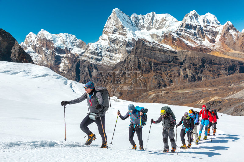 冒险家攀登高山，在冰川上行走正版图片素材
