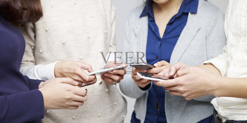 一群年轻人一起玩手机正版图片素材