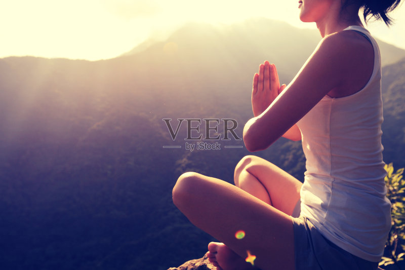 年轻的瑜伽女子在日出的山顶正版图片素材