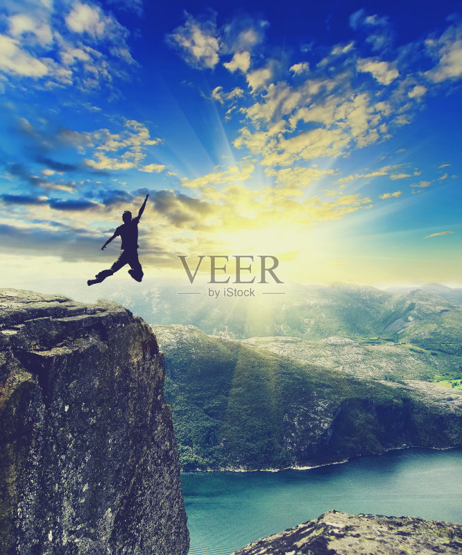 一个男人在挪威山顶上跳跃的剪影正版图片素材