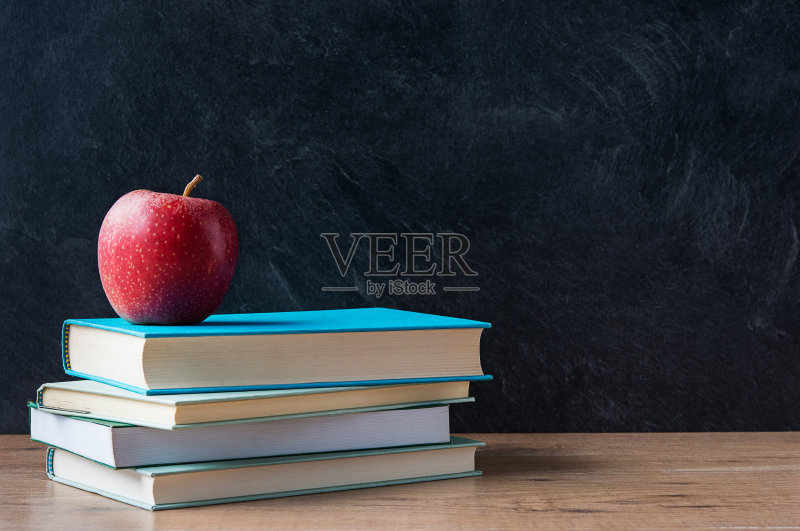 在学校的黑板前堆放在书上的苹果正版图片素材