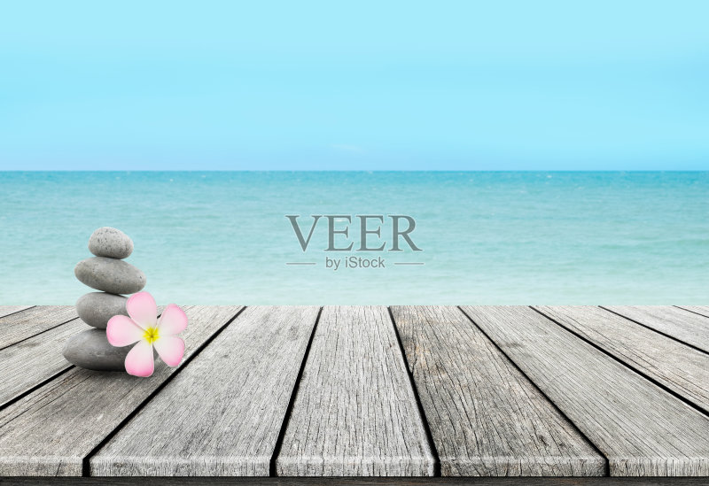 一堆鹅卵石堆在沙滩上的木头上正版图片素材