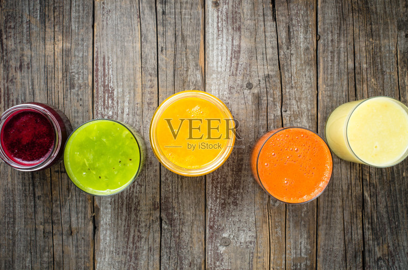 几杯新鲜的果汁放在木桌上正版图片素材