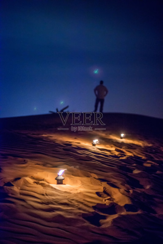 站在沙丘上仰望夜空的孤独男人正版图片素材