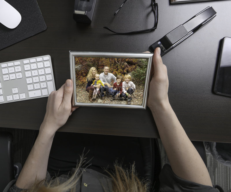 桌子前拿着全家福的女人正版图片素材