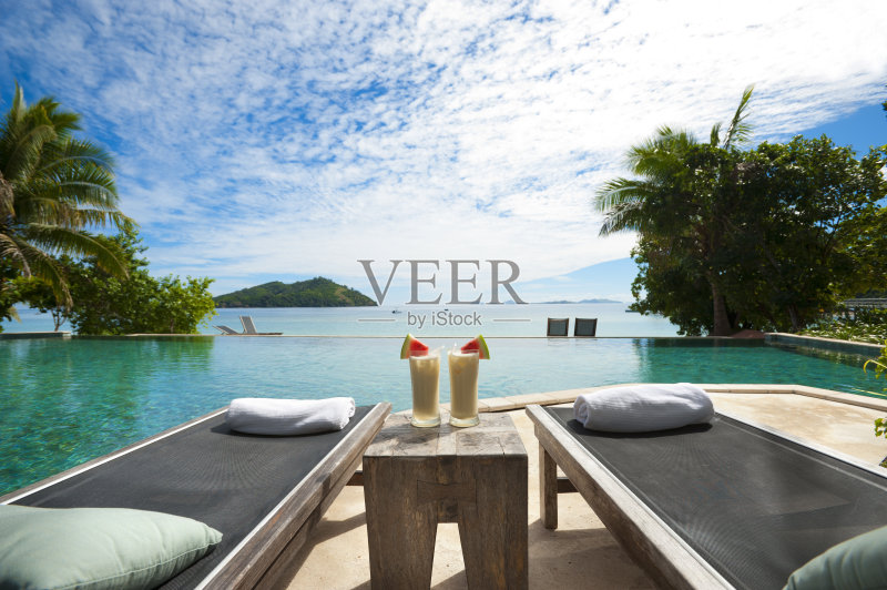 泳池边的休息室，桌上有鸡尾酒正版图片素材