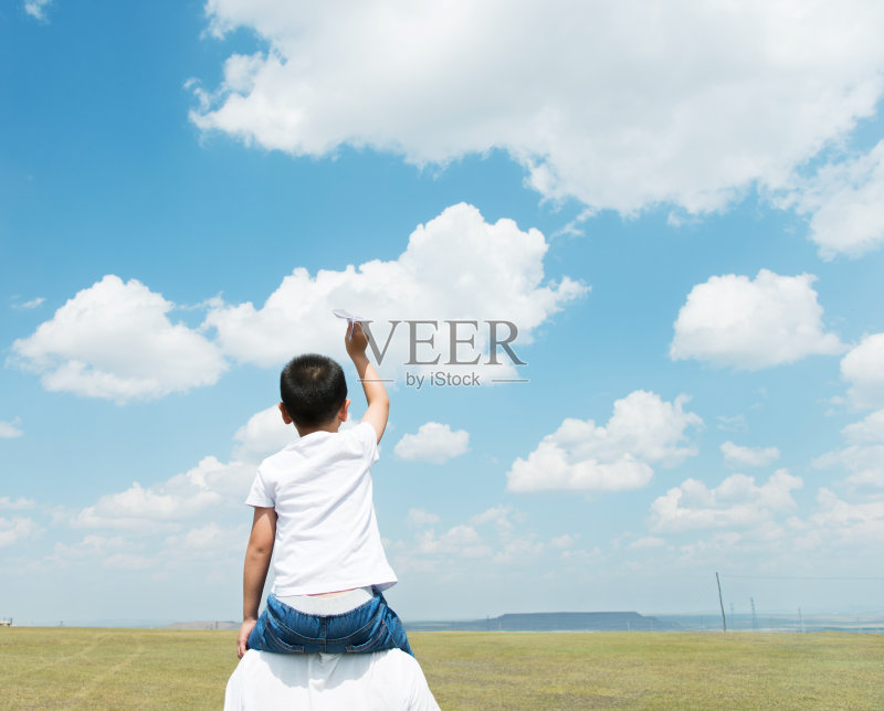 儿子和父亲在田野里玩纸飞机正版图片素材